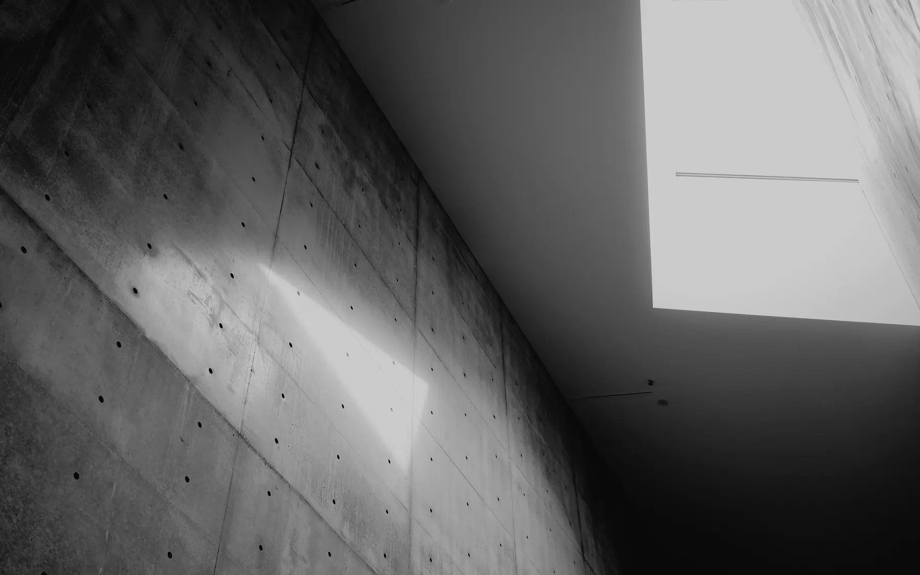Daylight raking across a bare concrete wall